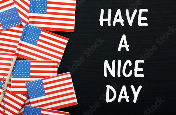 Fototapeta The phrase Have A Nice Day on a blackboard with flags