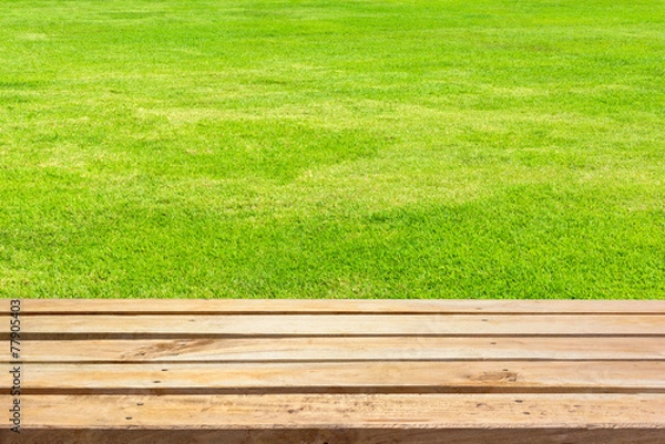 Obraz Empty wooden deck table on green grass background