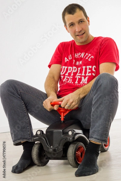Obraz Mann spielt mit Bobbycar