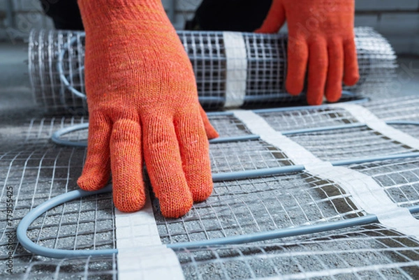 Fototapeta Underfloor electric heating. Underfloor heating cables with meshed support installation on a concrete screed floor. 