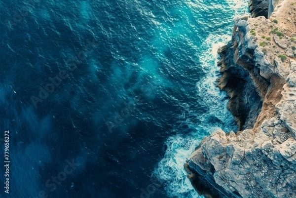 Fototapeta Aerial View of the Ocean and Cliffs, A panoramic aerial capture of a blue ocean and a rugged cliff, AI Generated