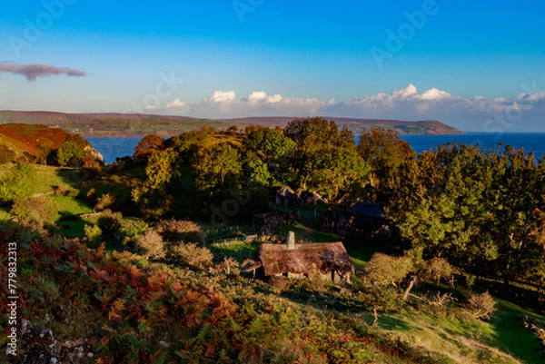 Fototapeta Traditional old irish house on the shores of the atlantic ocean with cloudy sky on sunrise hidden village of galboly europe