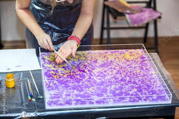 Fototapeta Painter hands splashing inks on water surface for marbling