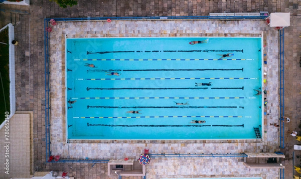 Obraz Several people training and exercising in a swimming pool while others watch