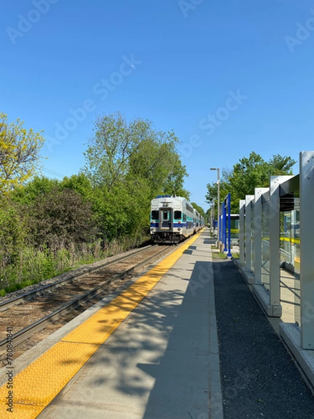 Fototapeta Tail end of train on the railway. City train at the station ready for departure. Suburban train arrival at the boarding platform. Display panel for travel times.