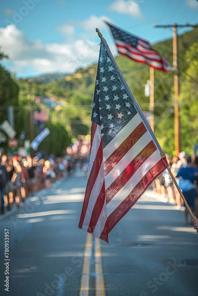 Fototapeta American flag waving in focus with blurred parade background, symbolizing national pride.