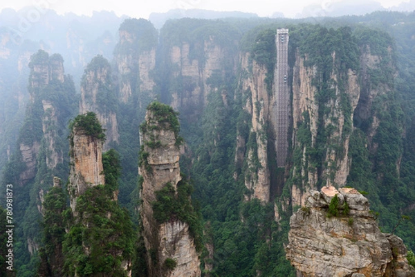Fototapeta Sandstone pillars rise above the lush forest of Zhangjiajie National Forest Park in Wulingyuan Scenic Area, China.
