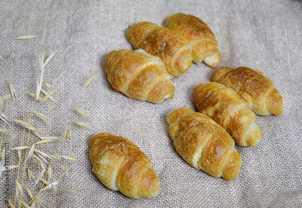 Fototapeta Small croissants on organic fabric in a natural beige color