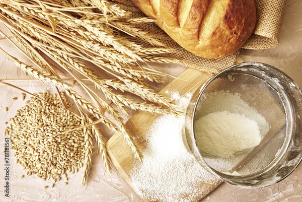 Fototapeta a loaf of bread,a sieve, coarse flour, grains and ears of wheat