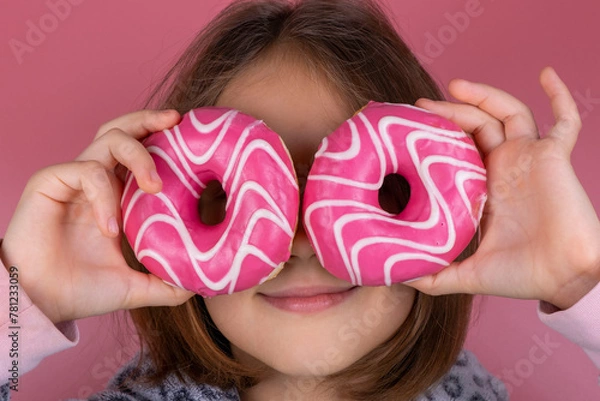 Obraz girl in kigurumi or pajamas with donuts in place of the eyes on a pink background