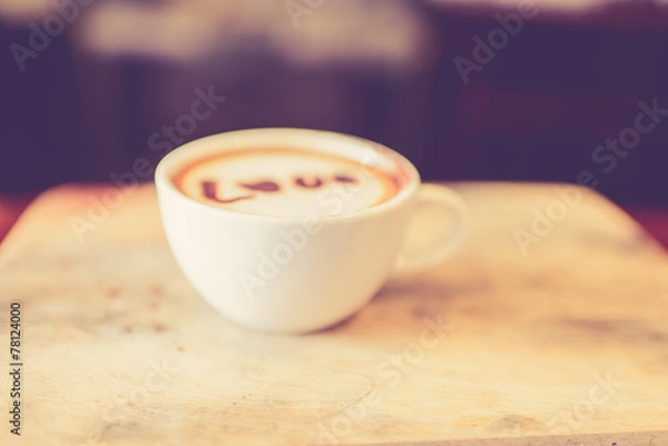 Fototapeta Blurred, Love message on coffee cup on wooden background with vi