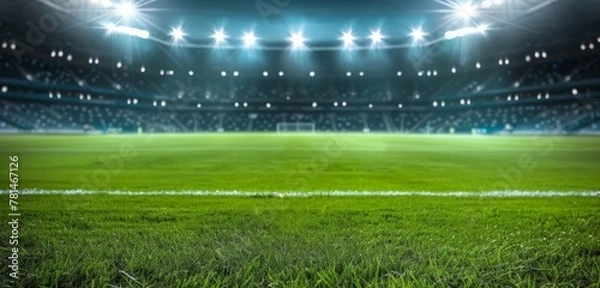 Fototapeta A soccer field with a bright green grass and a few lights in the background