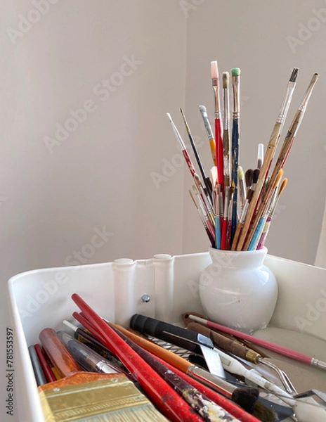 Fototapeta Paint brushes, spatula and artist material in a studio. Art supplies. Creative tools in a mobile cart.