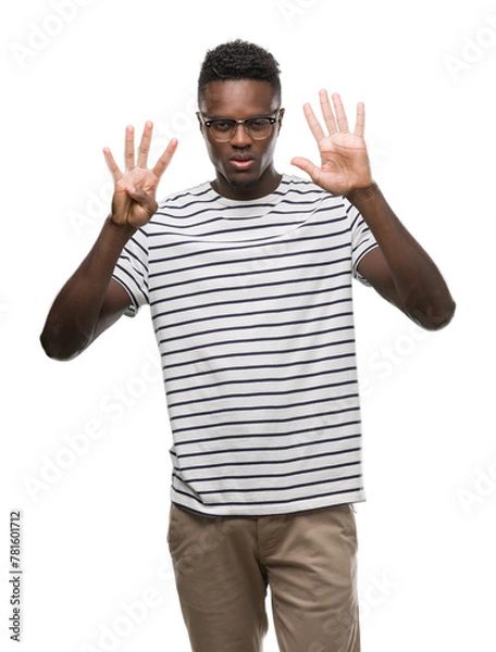 Fototapeta Young african american man wearing glasses and navy t-shirt showing and pointing up with fingers number nine while smiling confident and happy.