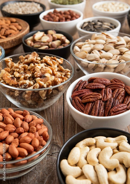 Fototapeta Raw walnuts and cashew with almonds and peanuts with organic nuts and seed in various assorted bowls.Macro