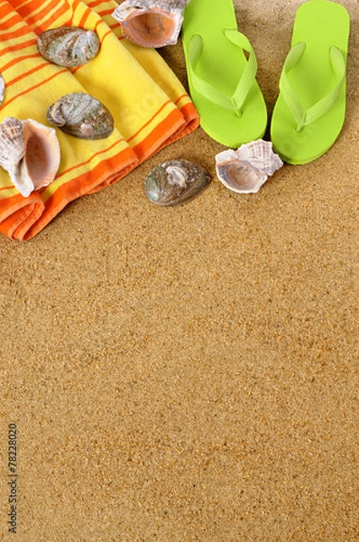 Fototapeta Beach sand background with towel seashells flip flop sandals summer holiday vacation photo vertical