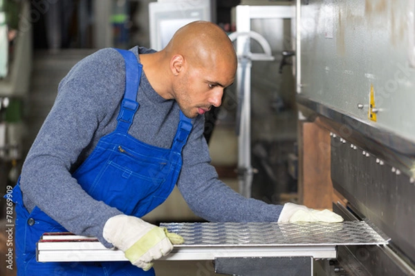Obraz Worker operating machine for bending sheet metal