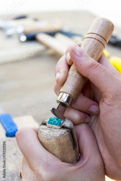 Fototapeta Stonesetting a rough amazonite gemstone using a ring clamp and a burnishing   tool