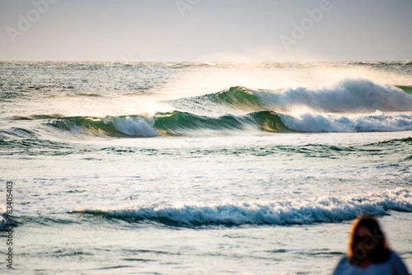 Fototapeta Small sunlit breaking waves near the shore