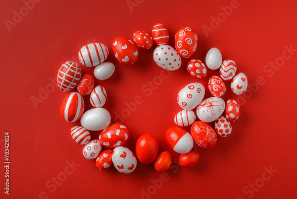 Fototapeta Easter backgrounds with a round frame of red and white Easter eggs on a bright red background. A place to copy. Flat image, top view.
