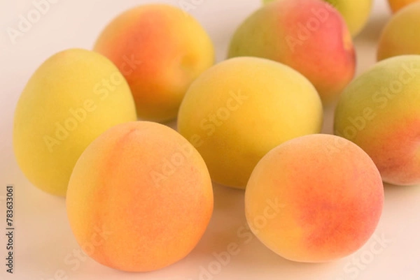 Fototapeta 白背景に生のウメの実、テーブルに置いたフレッシュな梅の実、熟した梅の実、完熟ウメ