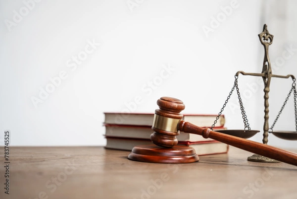 Fototapeta A brown wooden desk in a courtroom symbolizes authority and legal proceedings. It serves as a platform for lawyers to pursue justice, balancing equality and delivering judgments in the legal system.