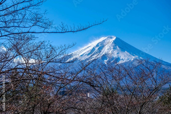 Fototapeta A distant view on Mt Fuji in Japan on a clear,The top parts of the volcano are covered with a layer of snow.