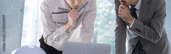 Obraz オフィスで働くビジネスマン　顔無しの考えるイメージのバナー