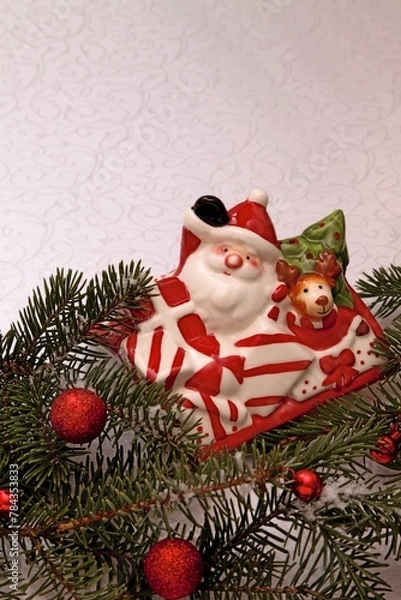 Fototapeta New Year's composition from a faience figurine of Santa Claus and fir branches.