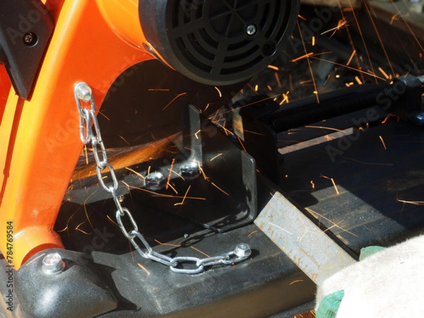 Obraz Sparks from cutting metal with angle grinder. Sparks while grinding iron.
The concept of locksmith work, processing of metal products.
