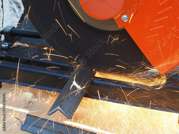 Obraz Sparks from cutting metal with angle grinder. Sparks while grinding iron.
The concept of locksmith work, processing of metal products.
