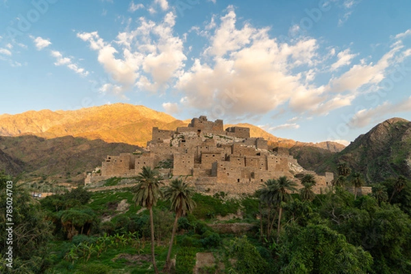 Fototapeta Thee Ain ancient village near Al-Bahah and Jeddah in Saudi Arabia with palm trees contrasting with desertic mountain in the Middle East