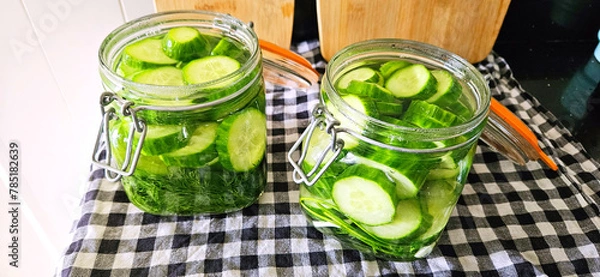 Fototapeta Canning cucumbers, homemade preparations. Pickling cucumbers in glass jars. Delicious and beautiful homemade food