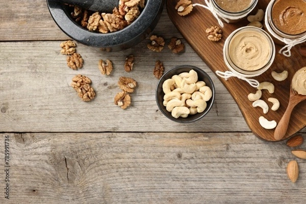 Fototapeta Making nut butters from different nuts. Fat lay composition with space for text on wooden table