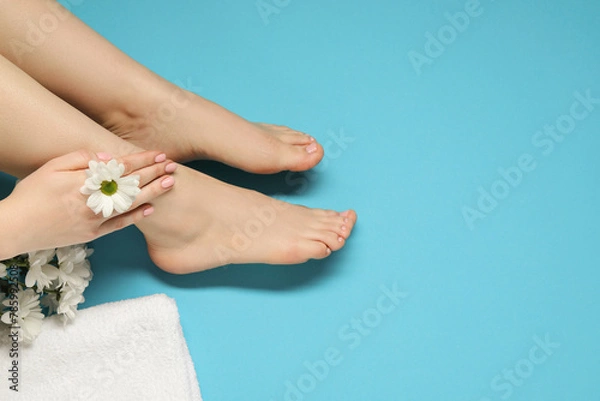 Fototapeta Woman with neat toenails after pedicure procedure on light blue background, closeup. Space for text