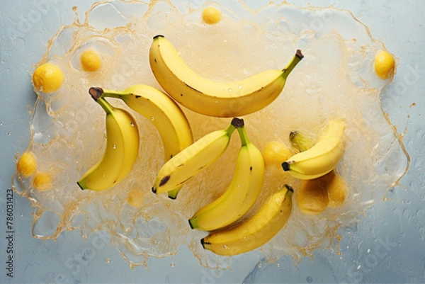 Fototapeta Bunch of bananas in water with splashes on color background, top view