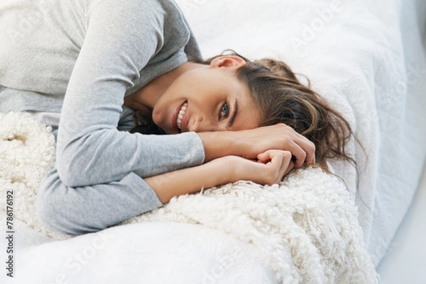 Fototapeta Happy, home and portrait of woman in bed for relaxing, resting and wake up from sleep in morning. Smile, house and face of person in bedroom with blanket on weekend, vacation and break for comfort