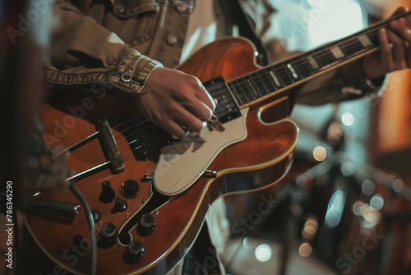 Fototapeta a musician's hands skillfully playing an electric guitar during a live performance, with a focus on artistry and action