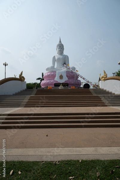 Fototapeta Saraburi, Thailand, April 14, 2024, Pasak Chonlasit Dam White Buddha.. A large white Buddha statue seated on a pink lotus base.