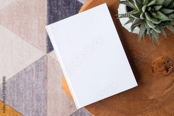 Fototapeta blank book mockup on coffee table with decorations and colorful rug