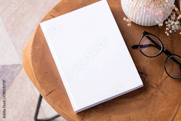 Fototapeta blank book mockup on coffee table with decoration flowers and colorful rug