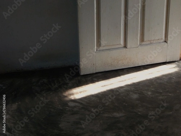 Fototapeta a light came in from the open door with the dark surroundings
