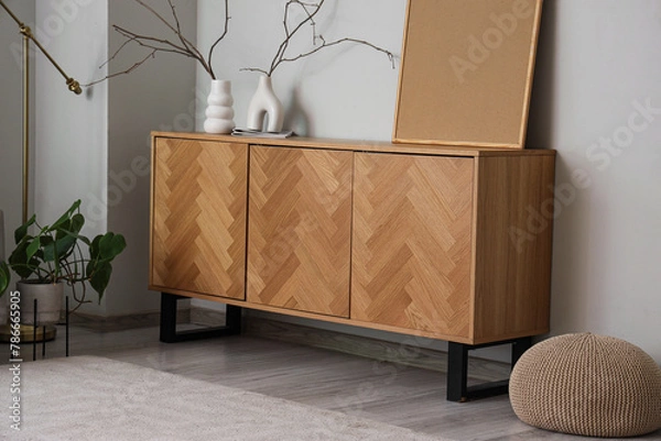 Fototapeta Wooden sideboard with vases and blank frame near grey wall in living room