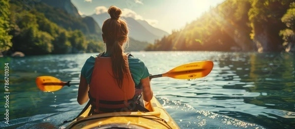 Obraz Solo female kayaking in serene stream in mountains, rear view, summer outdoor adventure concept