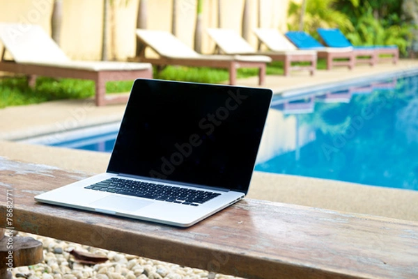 Obraz Vacation work with laptop on bench at pool