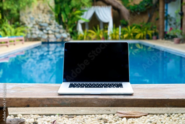 Obraz Vacation work with laptop on bench at pool