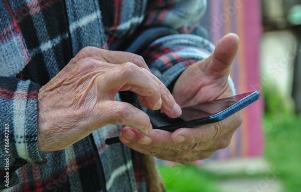 Obraz smartphone in the hands of an old man. old man using smartphone