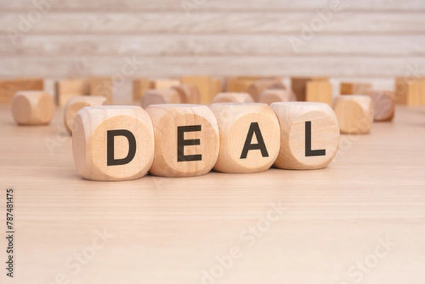 Obraz short word english text DEAL on a wooden cubes with wooden background