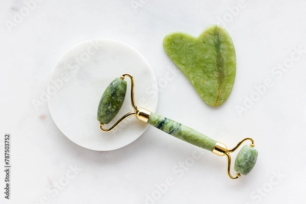 Obraz Green jade roller massager for face on white marble.