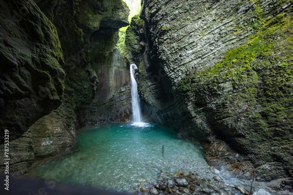 Fototapeta Caporetto, Slovenia. Kozjak waterfalls. Nature trail along the river with crystal clear, turquoise water, Tibetan bridges and a waterfall inside the cave with a nature pool. easy trekking, wood path.